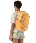 Patagonia 30L yellow refugio day backpack with a flower design  worn by an adult