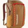 Patagonia 32L black hole packpack in talon gold. A 100% recycled polyester backpack in dark yellow and maroon detail. Features padded shoulder, side pockets for holding bottles and 2 compartments with cream branding on the front