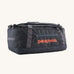 Patagonia 40 litres duffel bag in a dark navy blue colour on a cream background.