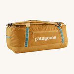 Patagonia 70 litres duffel bag in a gold colour on a cream background.