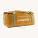 Patagonia 70 litres duffel bag in a gold colour on a cream background.