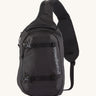 Patagonia 8L atom sling bag in a black colour on a cream background.