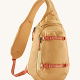 Patagonia 8L atom sling bag in a yellow colour on a cream background.