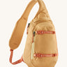 Patagonia 8L atom sling bag in a yellow colour on a cream background.