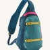 Patagonia 8L atom sling bag in a turquoise colour on a cream background.