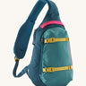 Patagonia 8L atom sling bag in a turquoise colour on a cream background.