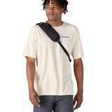Patagonia 8L atom sling bag in a black colour worn by an adult shoulder strap detail