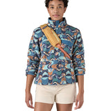 Patagonia 8L atom sling bag in a yellow colour worn by an adult shoulder strap detail