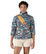 Patagonia 8L atom sling bag in a yellow colour worn by an adult shoulder strap detail