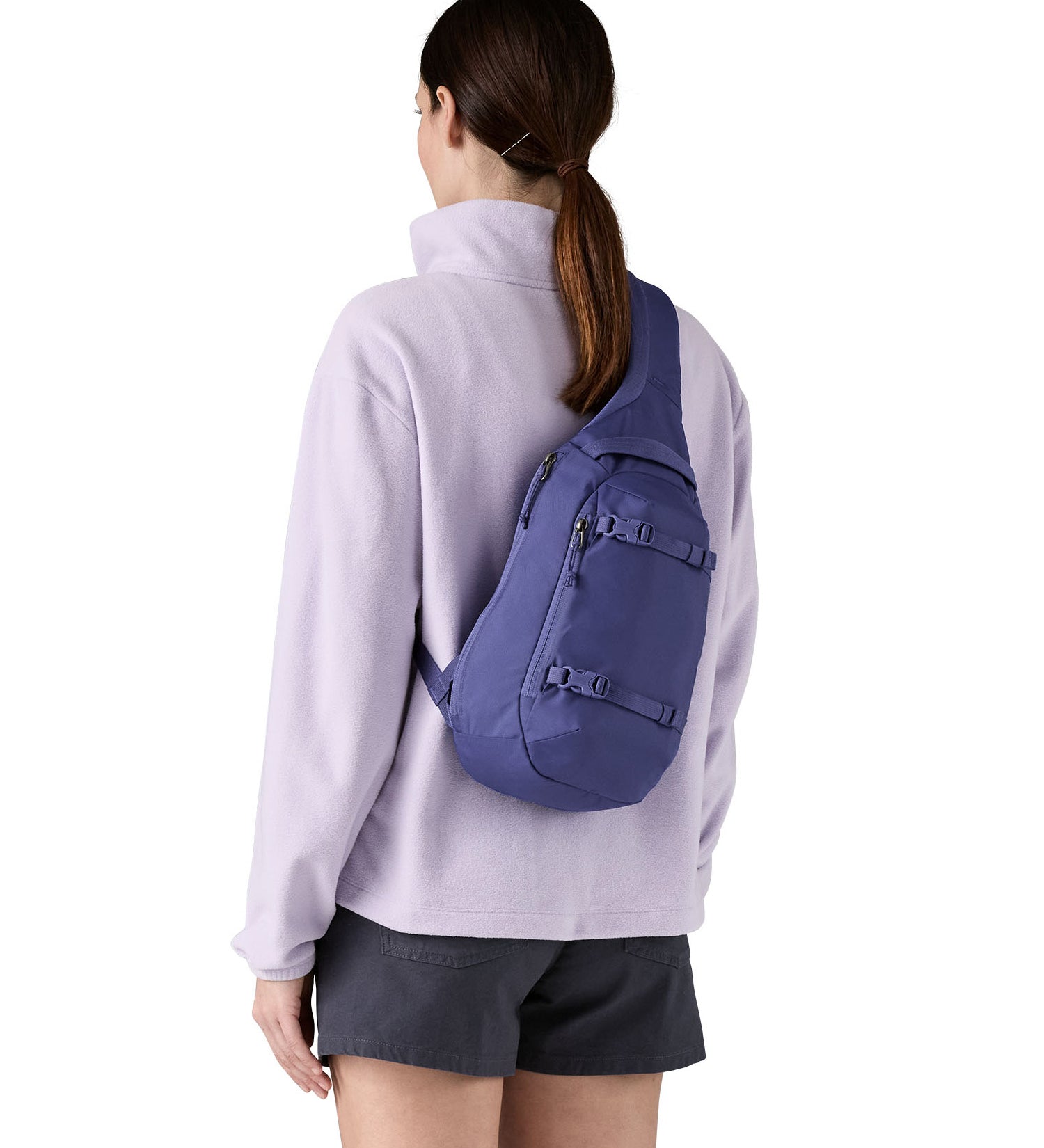Patagonia 8L atom sling bag in a purple colour worn by an adult