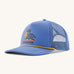 Patagonia broadcaster cap in blue colour on a cream background.