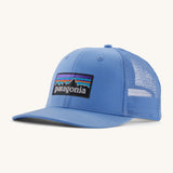 Patagonia adult trucker hat in blue on a cream background.