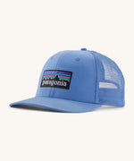 Patagonia adult trucker hat in blue on a cream background.