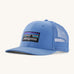 Patagonia adult trucker hat in blue on a cream background.