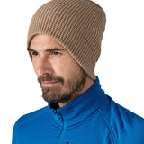Patagonia adult snow drifter beanie in a pale khaki colour worn by a adult with the brim turned down to give a it a more fuller fit