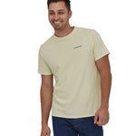 A man wearing a Patagonia Adult Fitz Roy Icon Responsibili-Tee in a Birch White colour stood in front of a plain background.