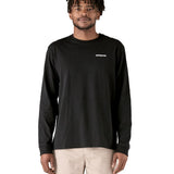 A adult wearing the black cotton Patagonia Adult  L/S P-6 Logo Responsibili-Tee. 