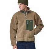 A man wearing a Patagonia Men's Classic Retro-X Jacket in a Seabird Grey colour and a green beanie hat.