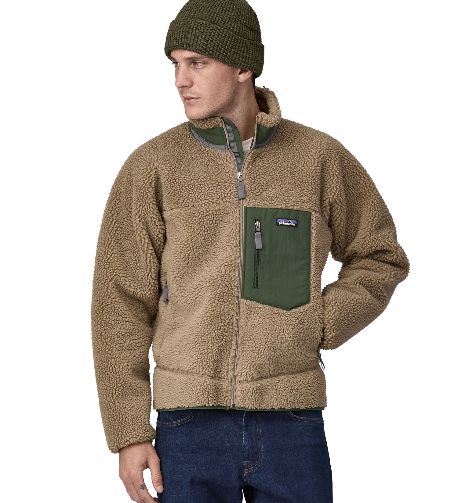 A man wearing a Patagonia Men's Classic Retro-X Jacket in a Seabird Grey colour and a green beanie hat.