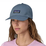 A woman wearing a Patagonia Adult P-6 Label Trad Cap in a mid utility blue colour.