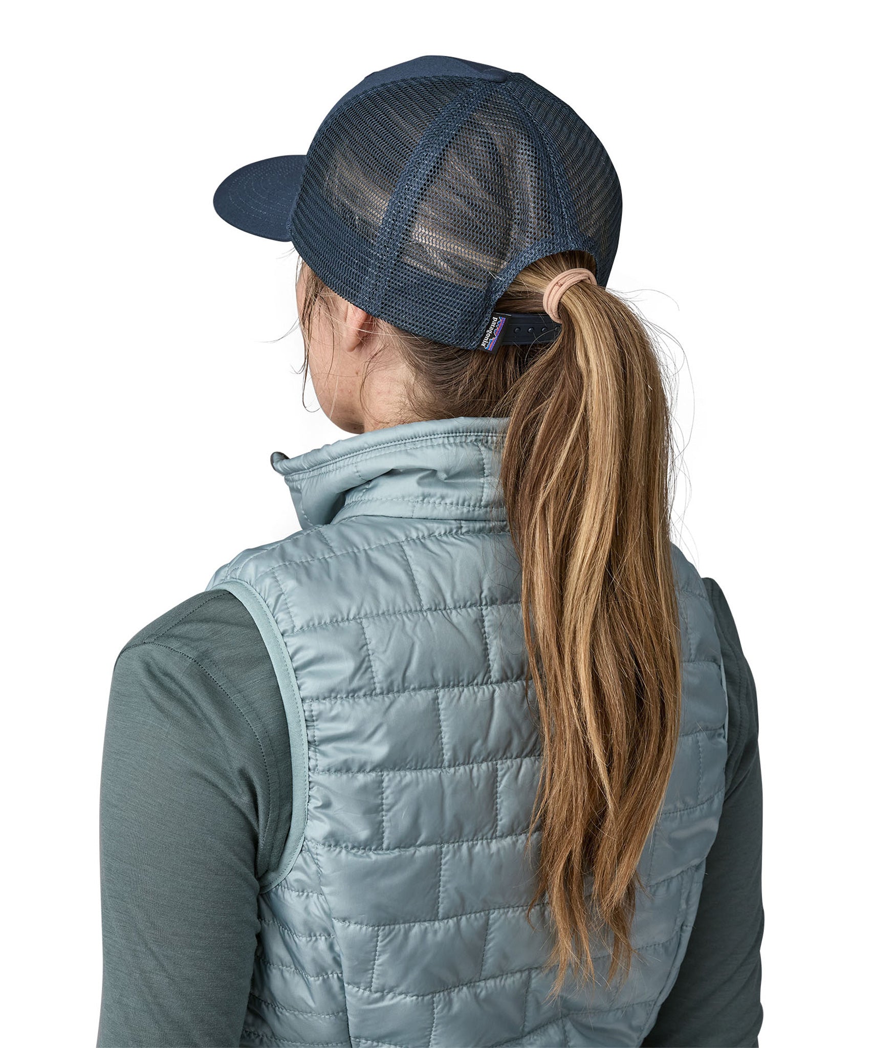 A woman wearing a Patagonia Adult P-6 Logo Trucker Hat in New Navy showing the back of the hat