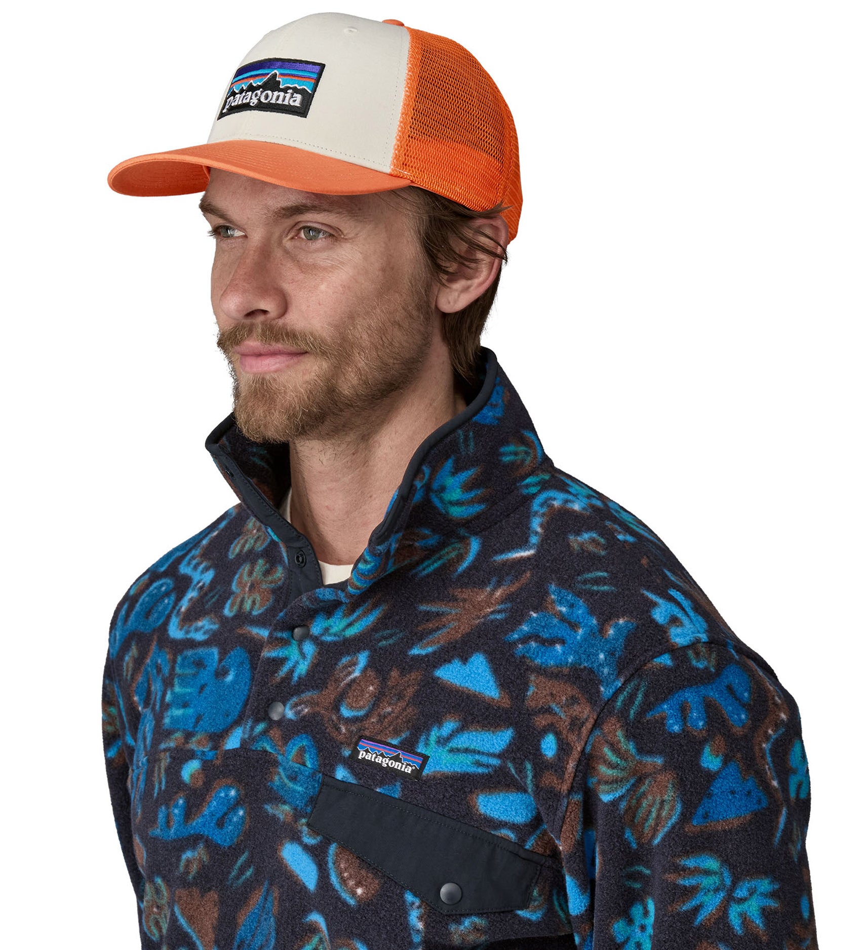 A man wearing a Patagonia Adult P-6 Logo Trucker Hat White Redtail Rust