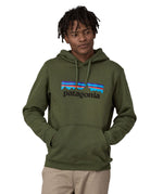 A man wearing a Patagonia Adult P-6 Logo Uprisal Hoody in a Torrey Pine Green colour, he is stood in front of a plain background.