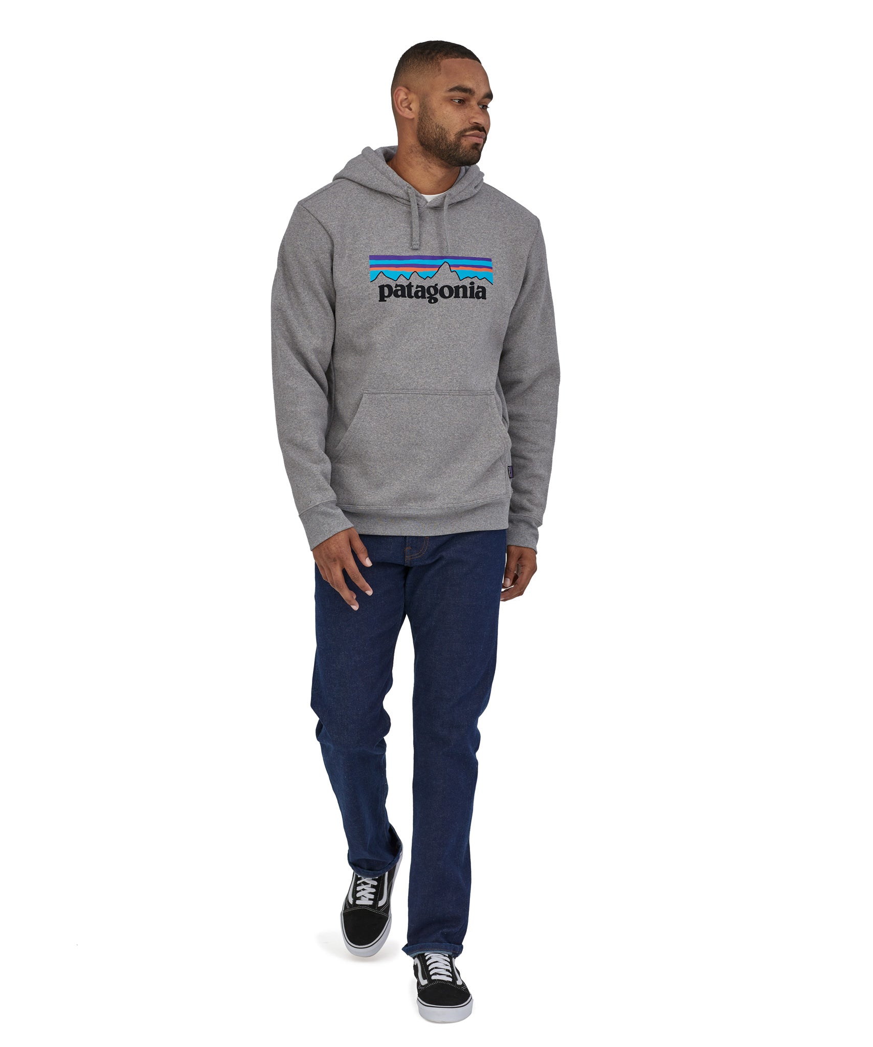 A man wearing a Patagonia Adult P-6 Logo Uprisal Hoody in a Gravel Heather grey colour stood in front of a plain background. 