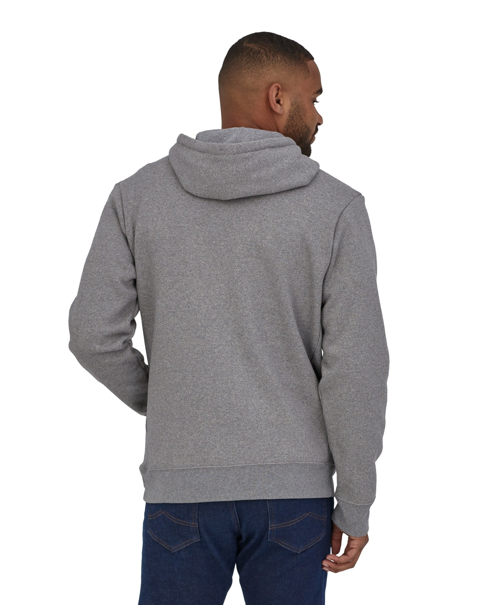 A man wearing a Patagonia Adult P-6 Logo Uprisal Hoody in a Gravel Heather grey colour stood in front of a plain background. He is facing away from the camera showing the back of the hoody. 