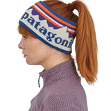 A side profile view of a woman wearing the Patagonia Adult Powder Town Headband Birch White