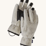 Alternative view of the Patagonia adult synchilla gloves in oatmeal heather. Features a grip on the palms and fingertips. Logo label is stitched on the side with a clip on each glove for easy carrying