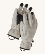 Alternative view of the Patagonia adult synchilla gloves in oatmeal heather. Features a grip on the palms and fingertips. Logo label is stitched on the side with a clip on each glove for easy carrying