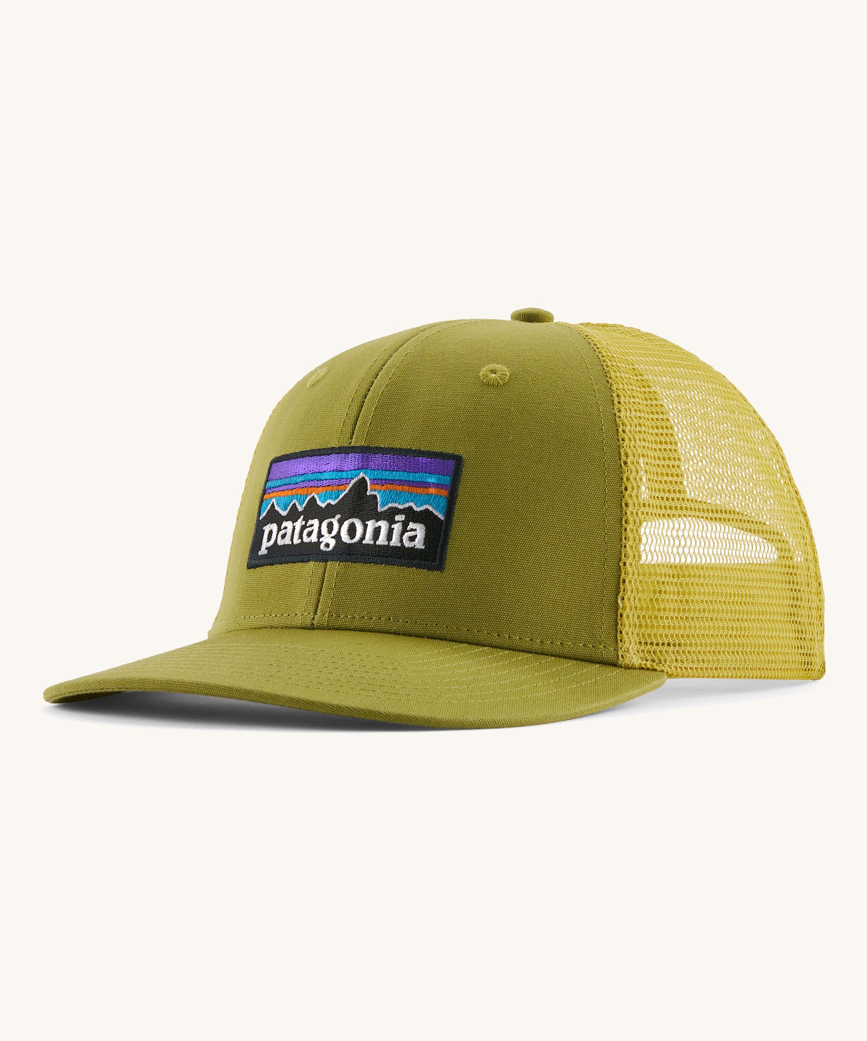 Patagonia adult trucker hat in green colour on a cream background.
