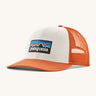 Patagonia adult trucker hat in white and orange colour on a cream background.