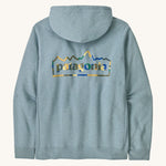 Patagonia adult unity hoodie in thermal lue with the logo design on the back on a cream backgroud.