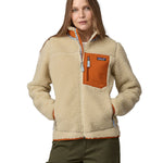 A woman wearing a Patagonia Women's Classic Retro-X Jacket in a Dark Natural colour standing against a plain background.