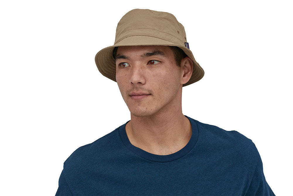 Man stood on a white background wearing the Patagonia mojave khaki bucket hat