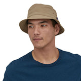 Man stood on a white background wearing the Patagonia mojave khaki bucket hat