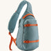 Patagonia atom sling 8L bag in blue sage with orange handle straps, gear loops and quick release buckles. 