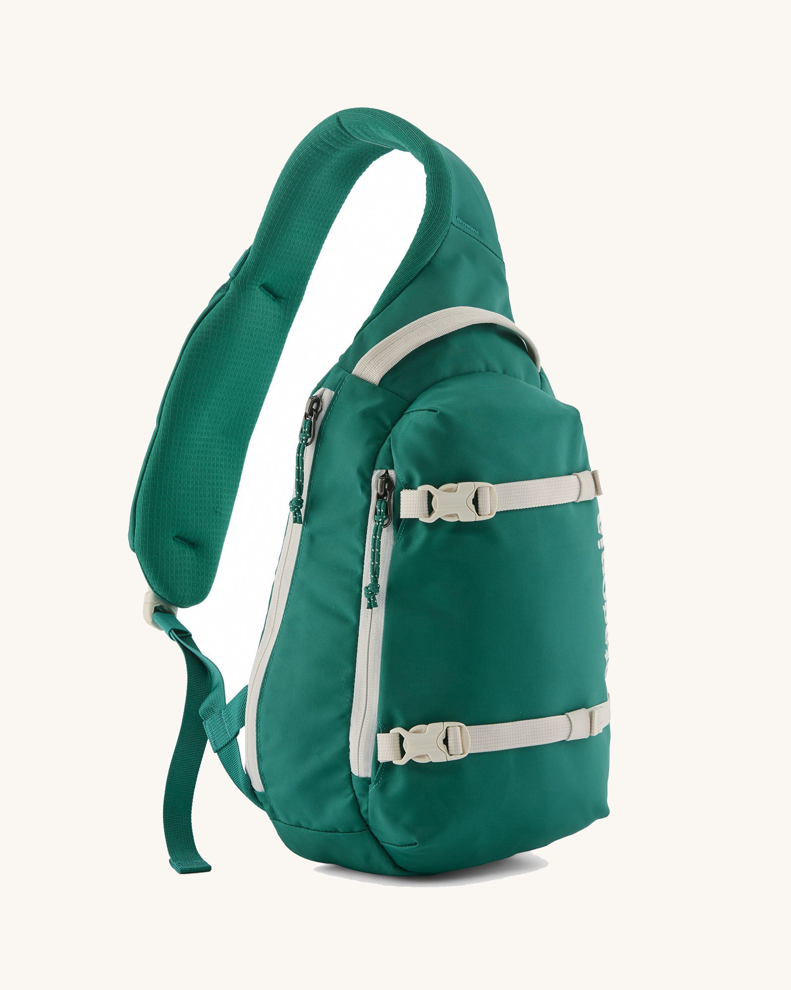 Patagonia atom cross body 8L sling bag in gem green with grey handle, zips, gear straps and buckles.
