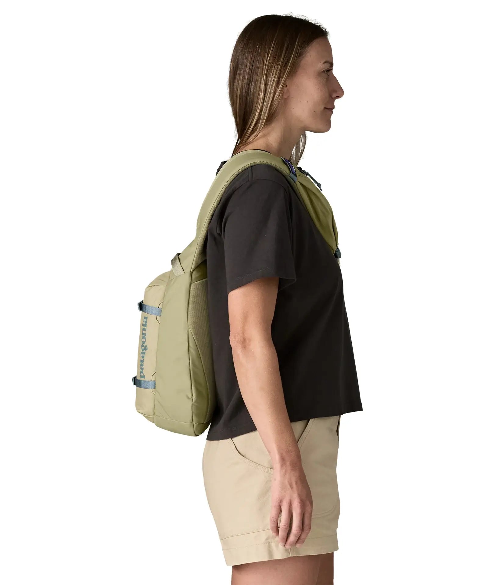 Side of woman wearing the Patagonia atom cross body 8L sling bag in pale green over the shoulder