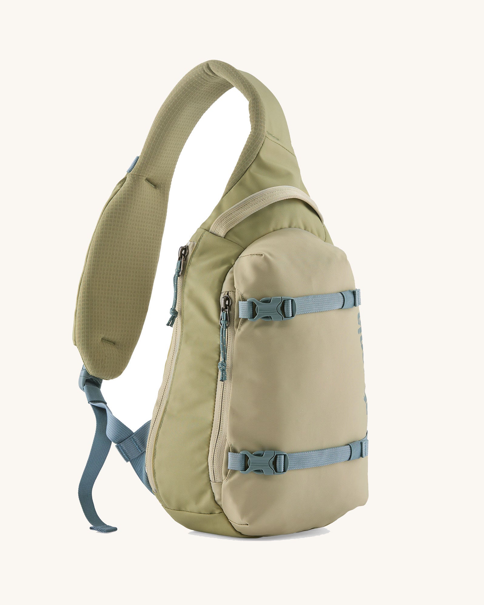 Patagonia atom cross body 8L sling bag in weathered stone with grey gear straps and buckles.