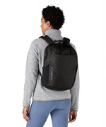 Person wearing the Patagonia atom 20 litre black tote bag backpack on their back.