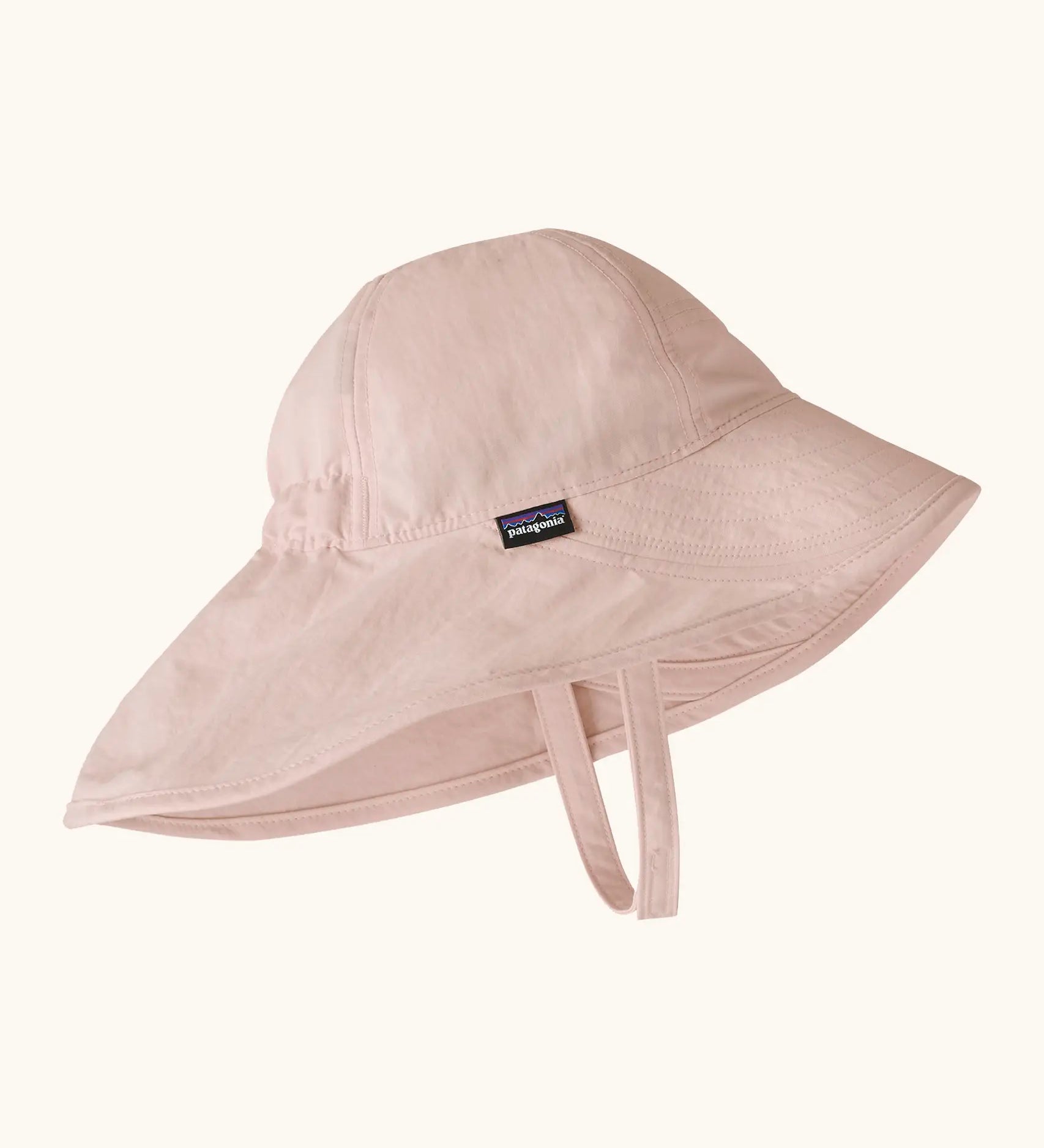 Patagonia little kids recycled nylon sun block hat in pale pink. Features a wide neck protector panel and chin strap