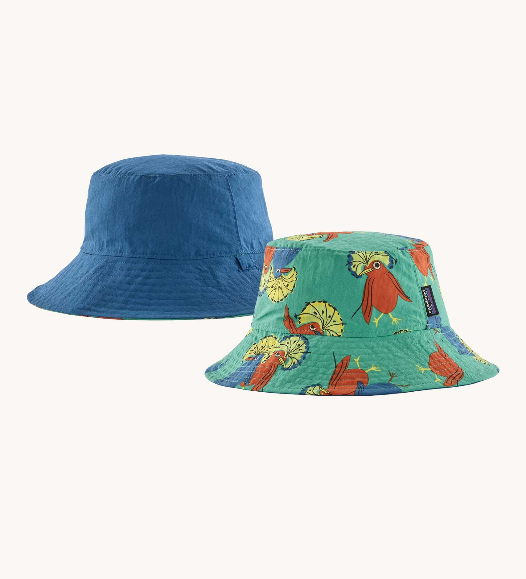 Patagonia reversible baby sun bucket hat one side with a royal fren bird print on an aqua background the other side is plain blue.