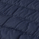 A close up of water droplets shown on the outer material of the Patagonia Little Kids Down Sweater - New Navy. 