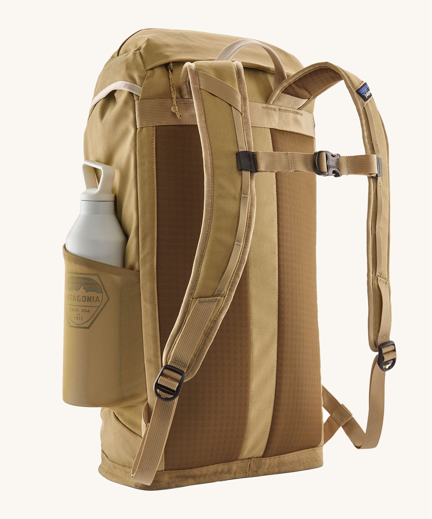 Patagonia lid fieldsmith lid backpack in classic tan showing the Shoulder strap detail with buckle fastening. Features a side mesh pocket for holding water bottles. 