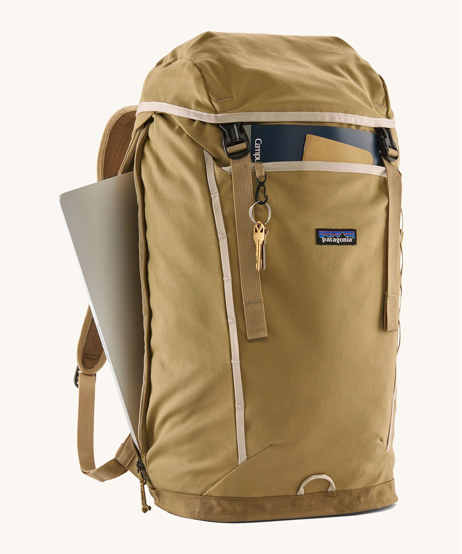 Patagonia lid fieldsmith lid backpack in classic tan with the side zip open for storing a laptop a clip for keys and a handy front compartments for maps and small notepads.