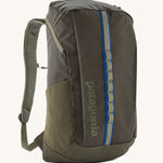 Patagonia 25L black hole backpack in a basin green colour on a cream backgrobund.