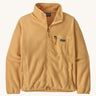 Patagonia synchilla fleece in a beeswax tan colour on a cream background.